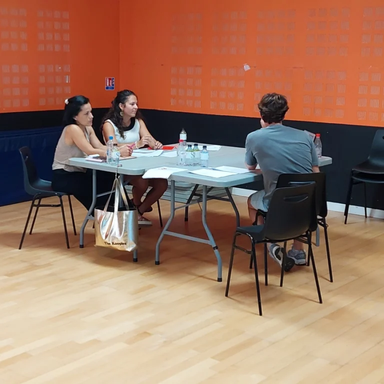 Table ou sont assise trois personnes, dont un candidat devant deux jurys