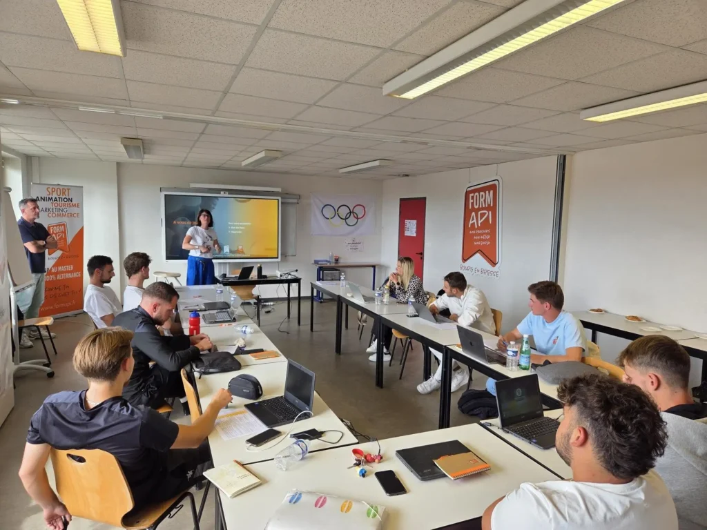 classe ou plusieurs étudiants sont assis, et écoute le professeur parler au tableau