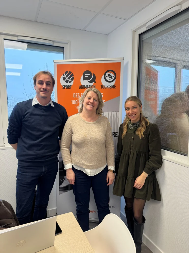 Trois personne se tenant côté à côté, souriant, dont Brigitte Henriques au milieu, un homme à a gauche et une femme à sa droite