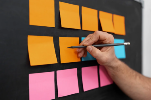 Gros plan sur un tableau noir où sont collés une dizaine de post-it colorés