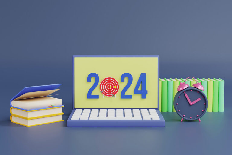 Inscription scolaire 2024 - BLog - Ordinateur indiquant l'année 2024 avec une cible à la place du 0, à côté des piles de livres et un réveil ancien