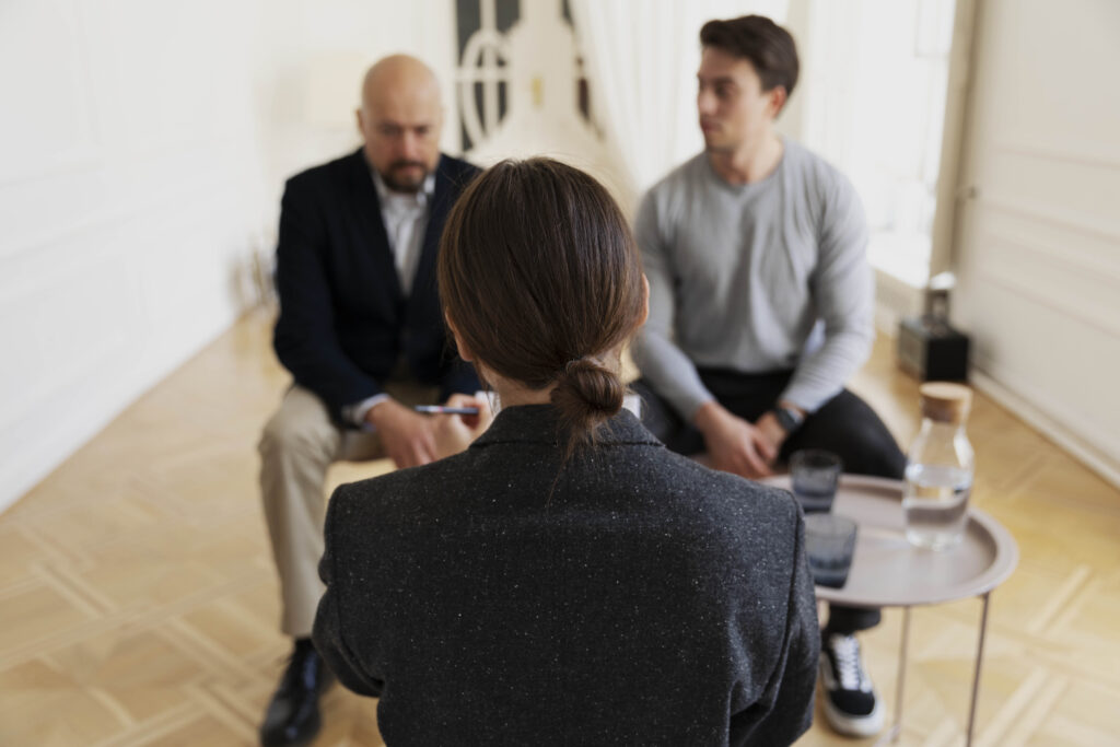 Médiateur vu de dos, face à deux hommes